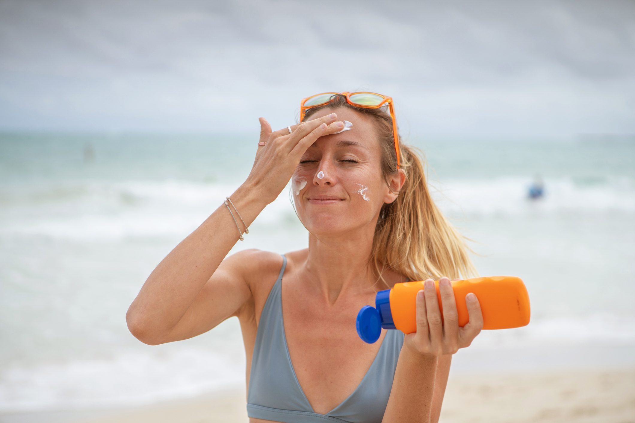 woman applying sunscreen on the beach