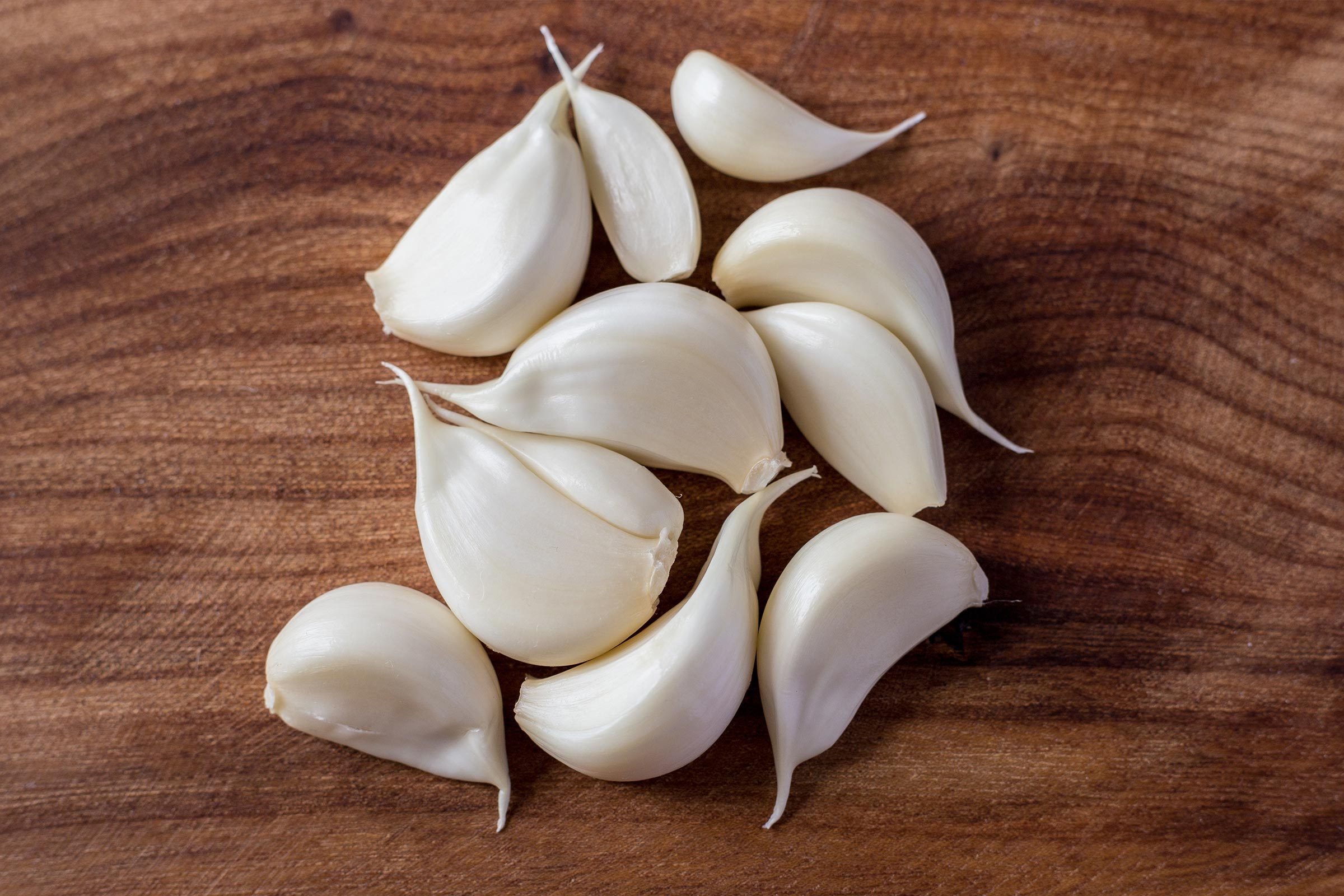 Jar with garlic cloves and heads on plate