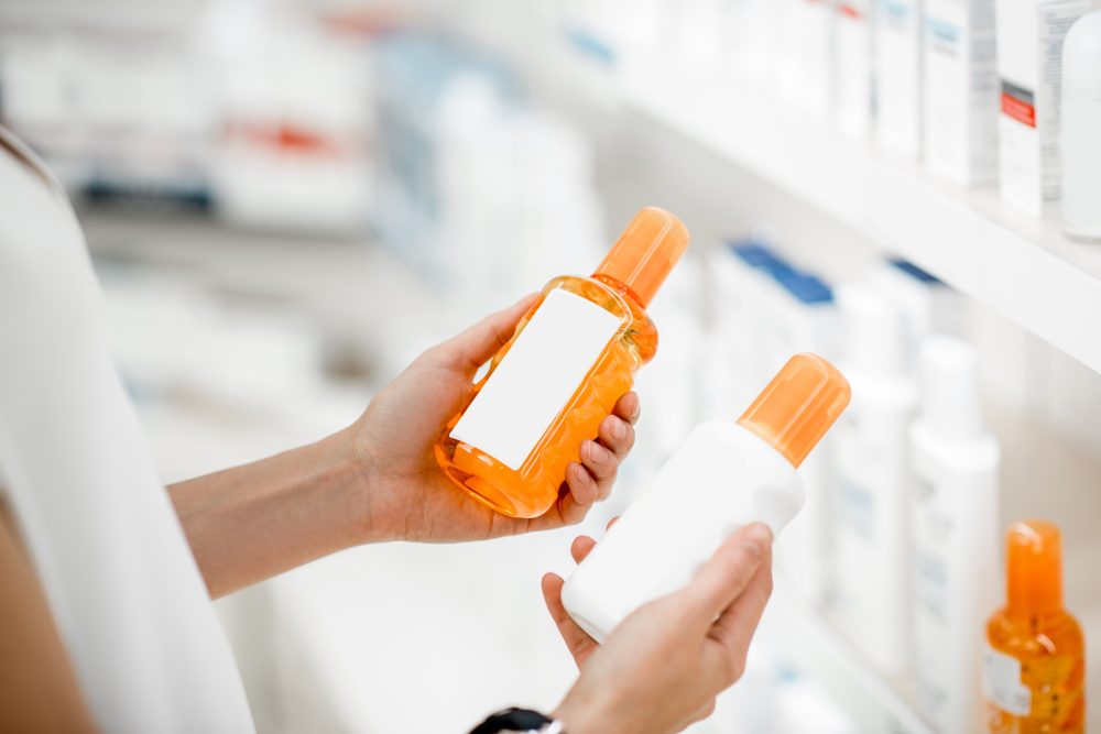 shopper holding two bottles of sunscreen