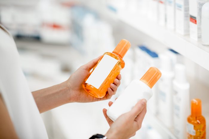 shopper holding two bottles of sunscreen