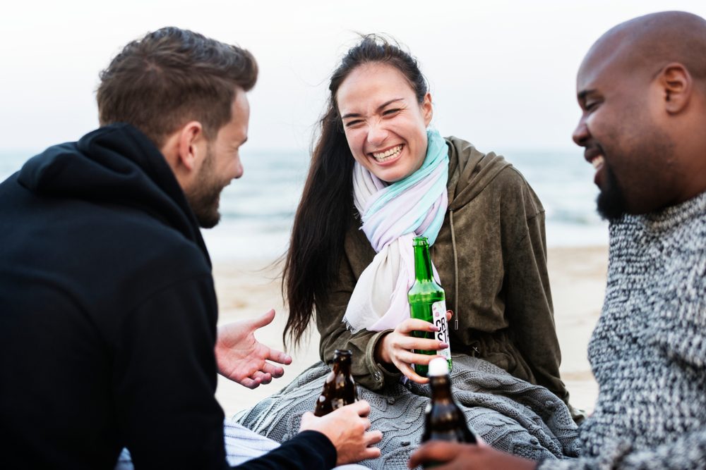 Friends drinking beer on the beach