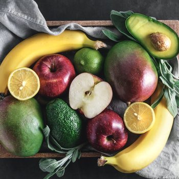 Top view of fresh fruits in the wooden box on black.