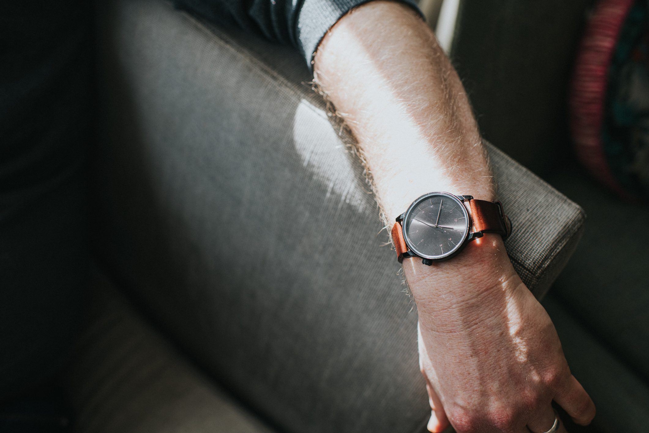 man's arm on couch showing watch