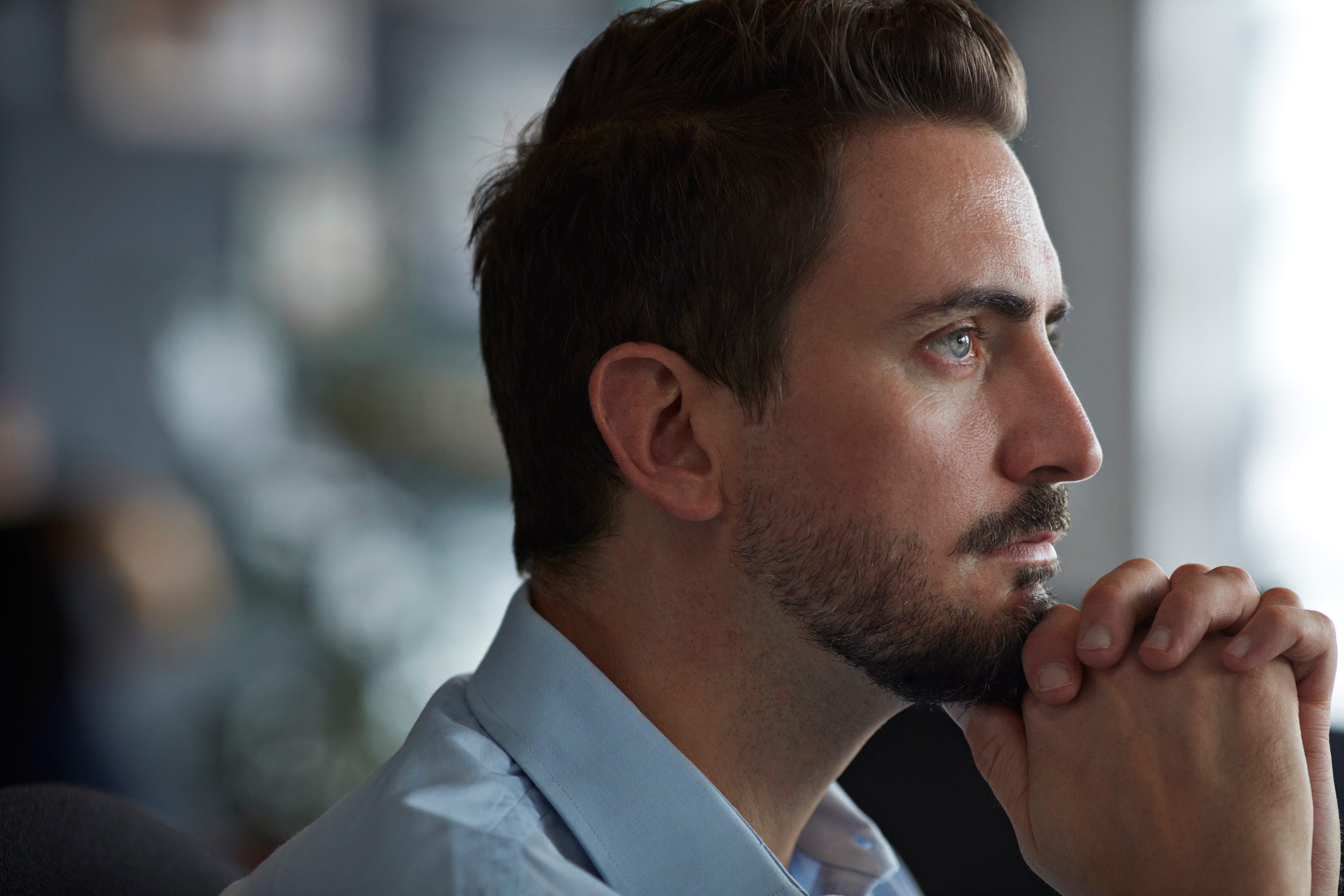 business man looking out window stressed