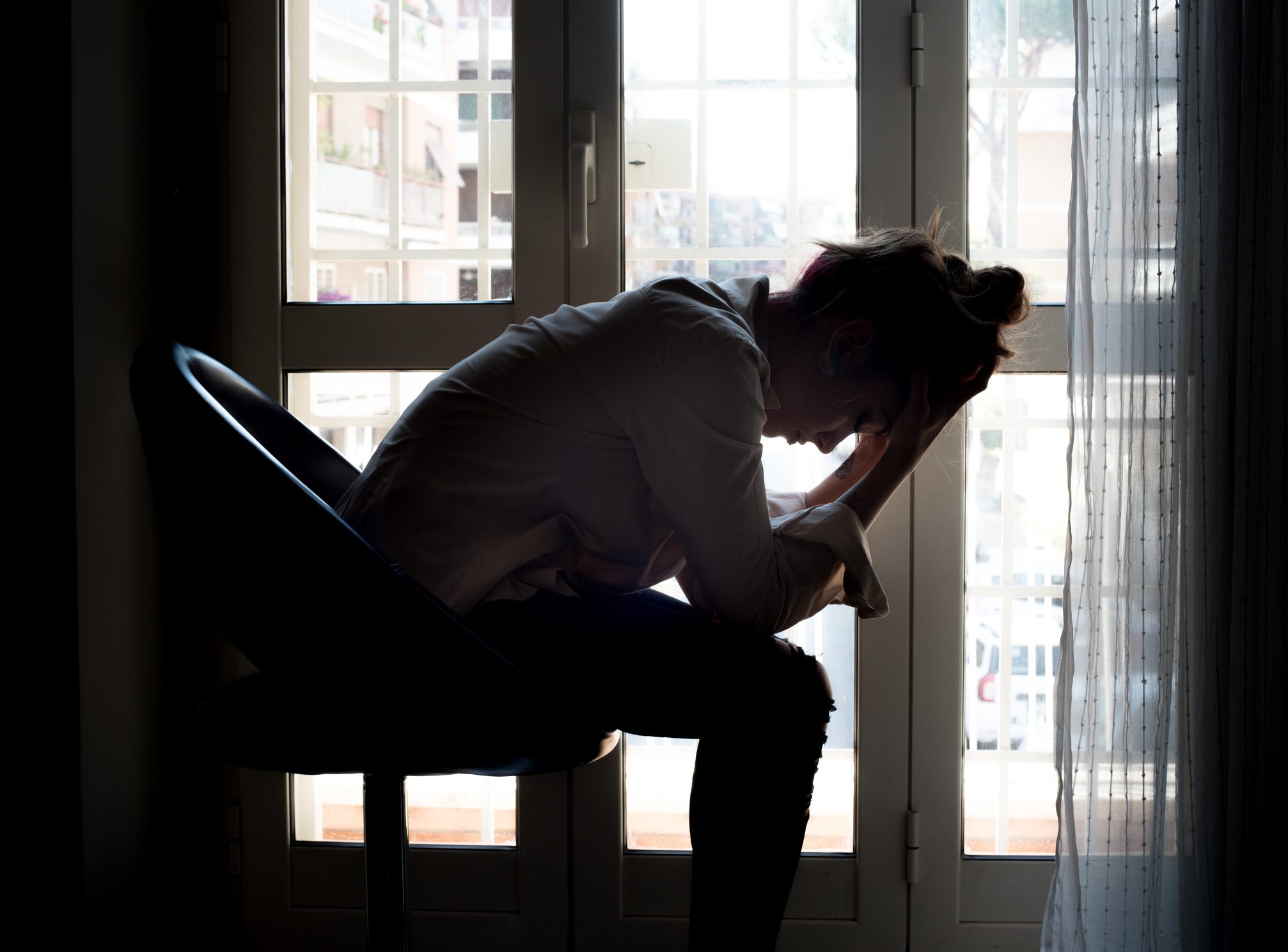 woman sitting in room overthinking