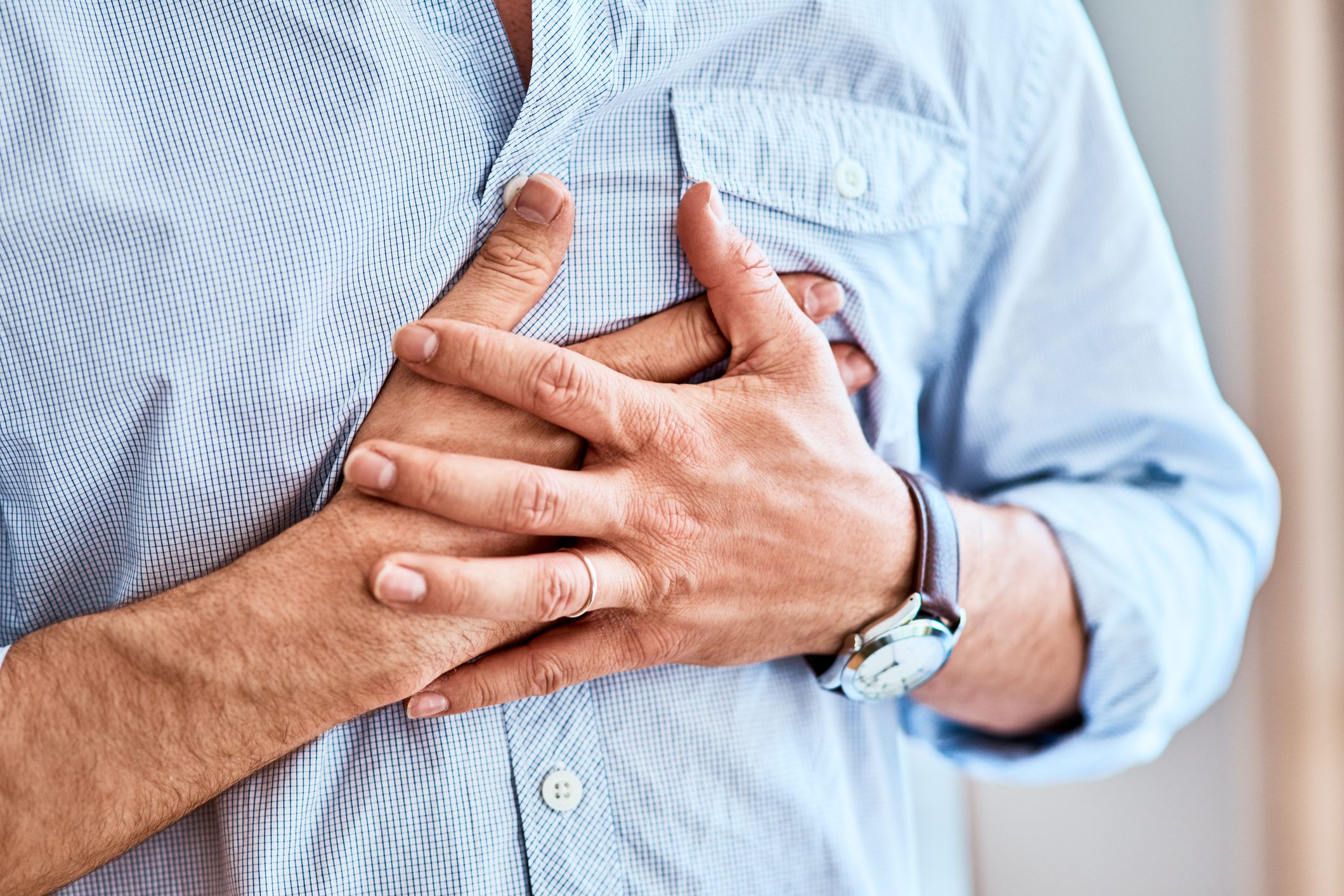 close up of man holding his chest