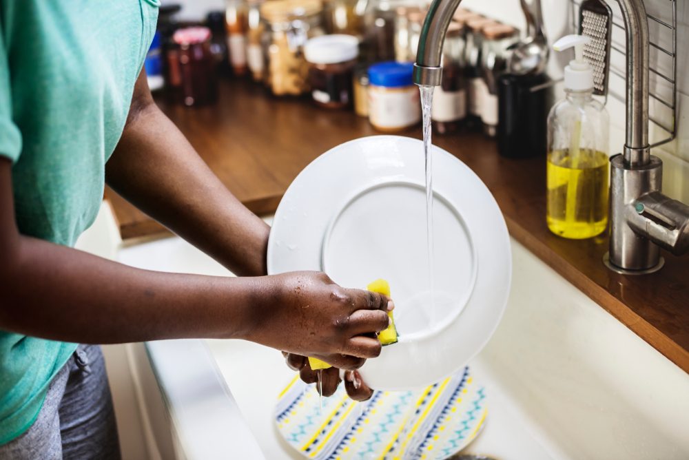woman washing a dish in sink