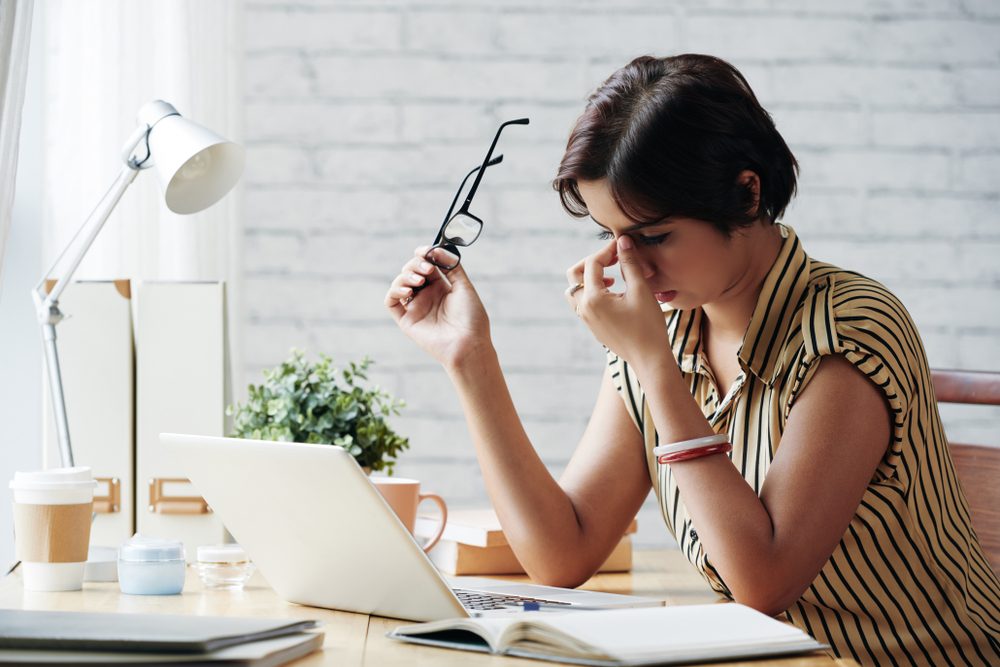 Stressed or tired business lady rubbing her eyes