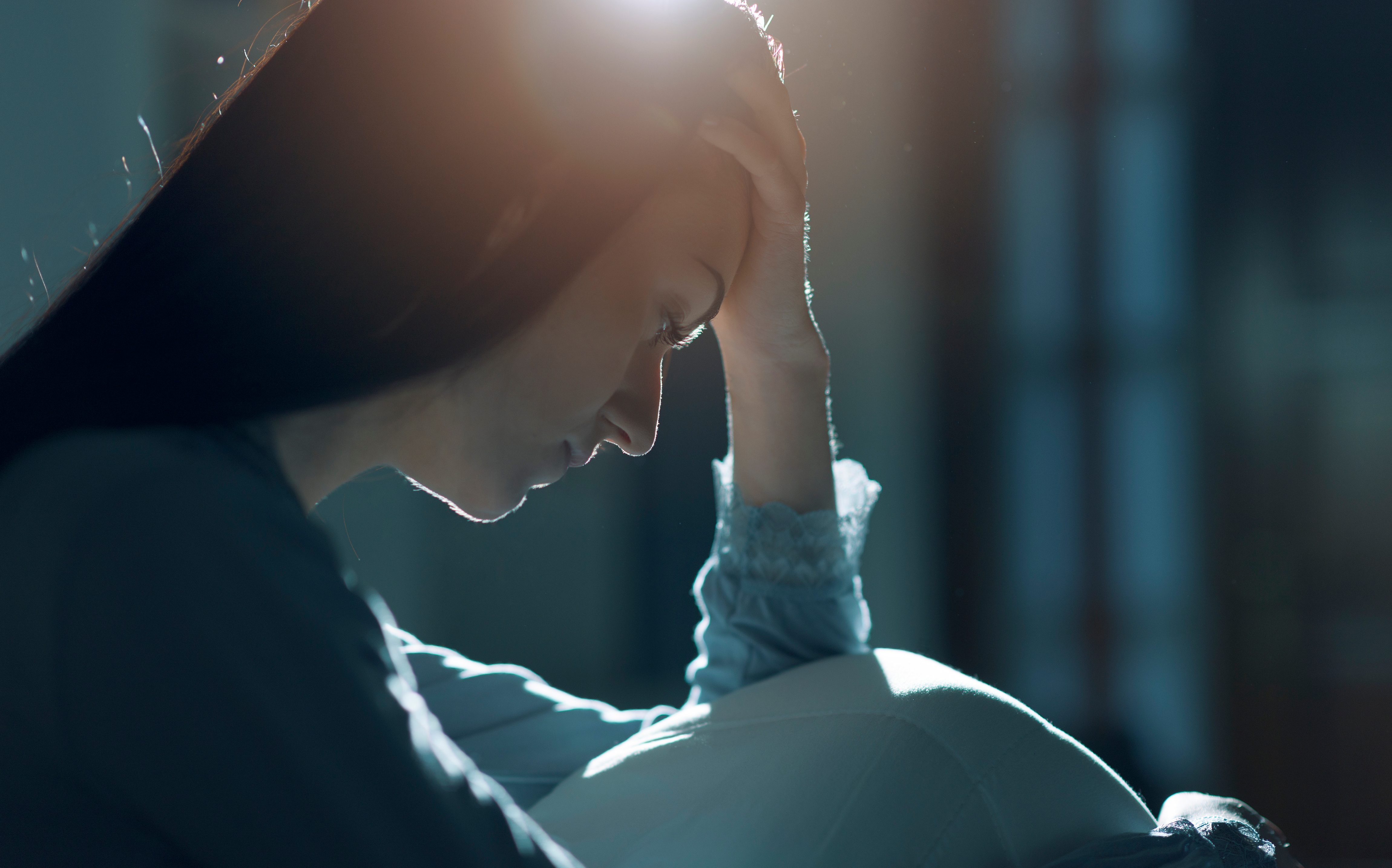 depressed woman hand on head bed night