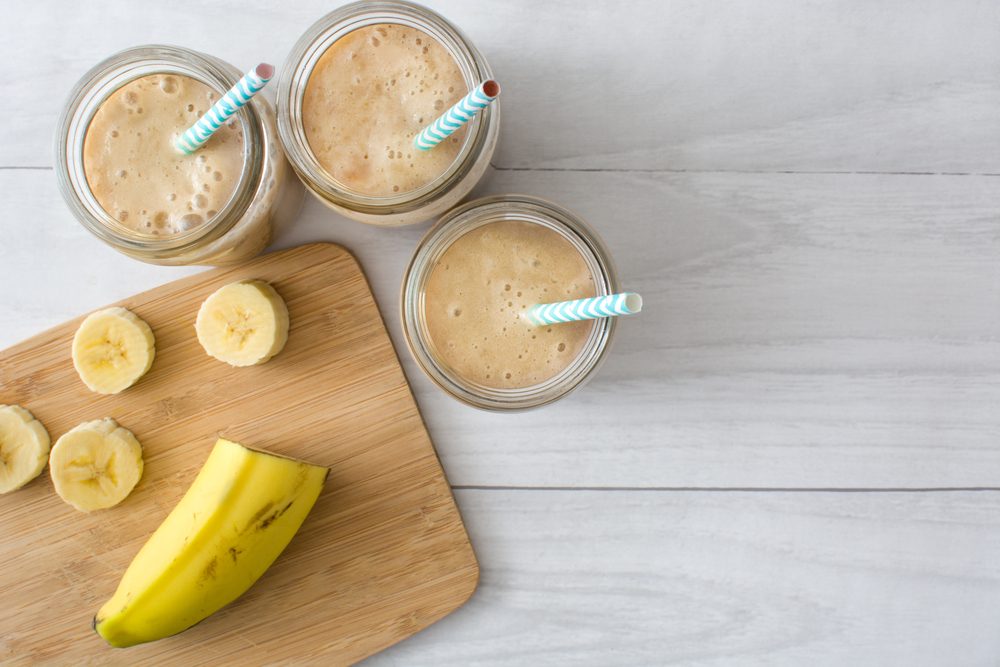 Banana smoothie on a white wooden table