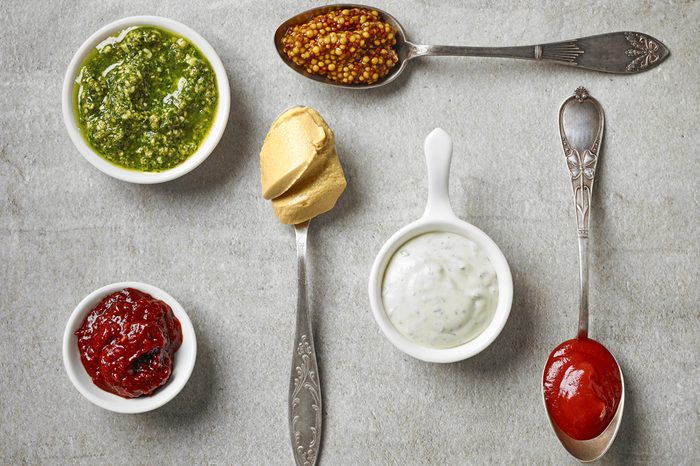 Various condiments in bowls and spoons.