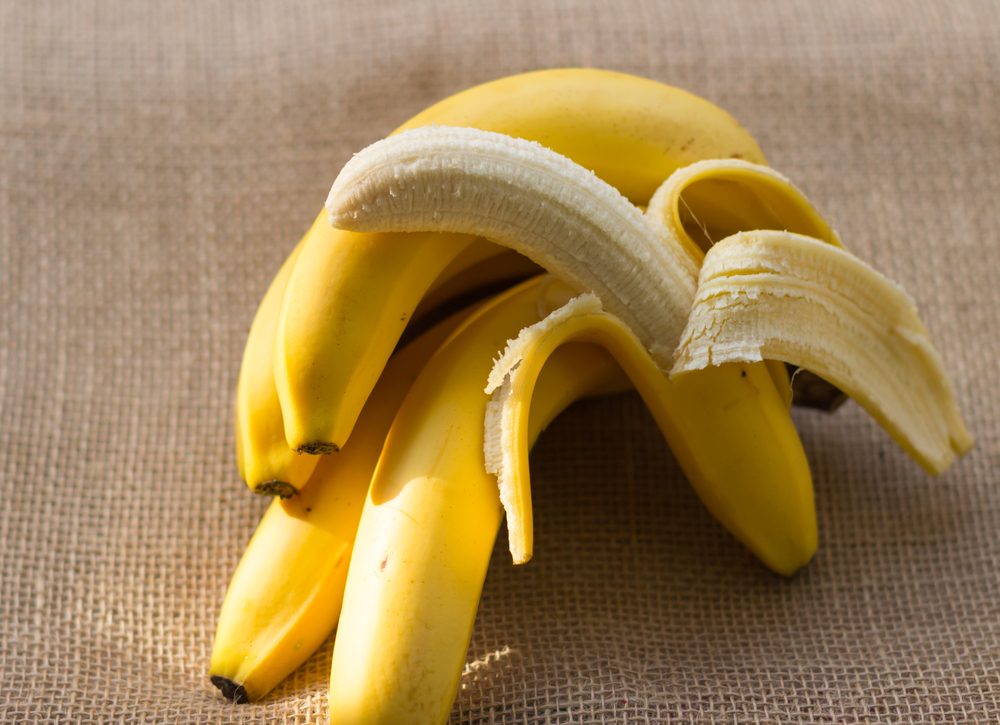 bunch of bananas and one peeled banana