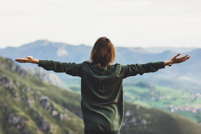 woman outdoors with arms outstretched