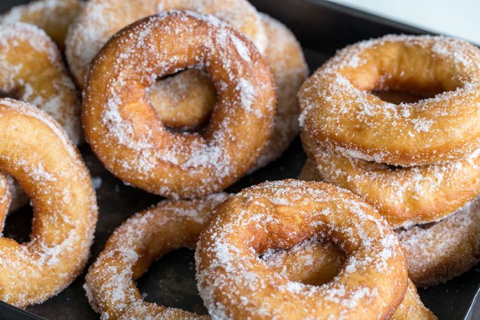 Homemade donuts with sugar and sugar powder in old metal background.