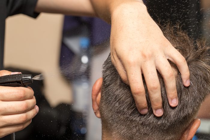 spraying with hair spray in beauty salon