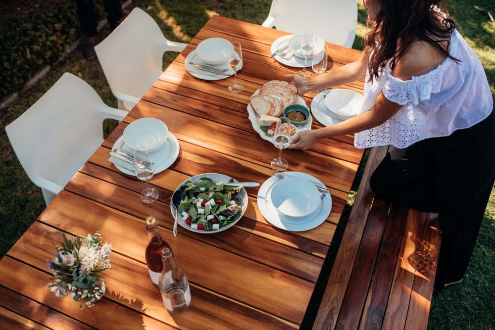 woman setting food on table for party