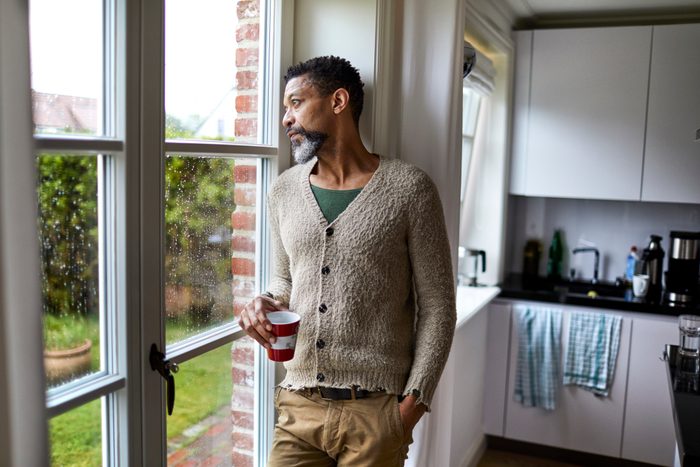 man looking pensively out window