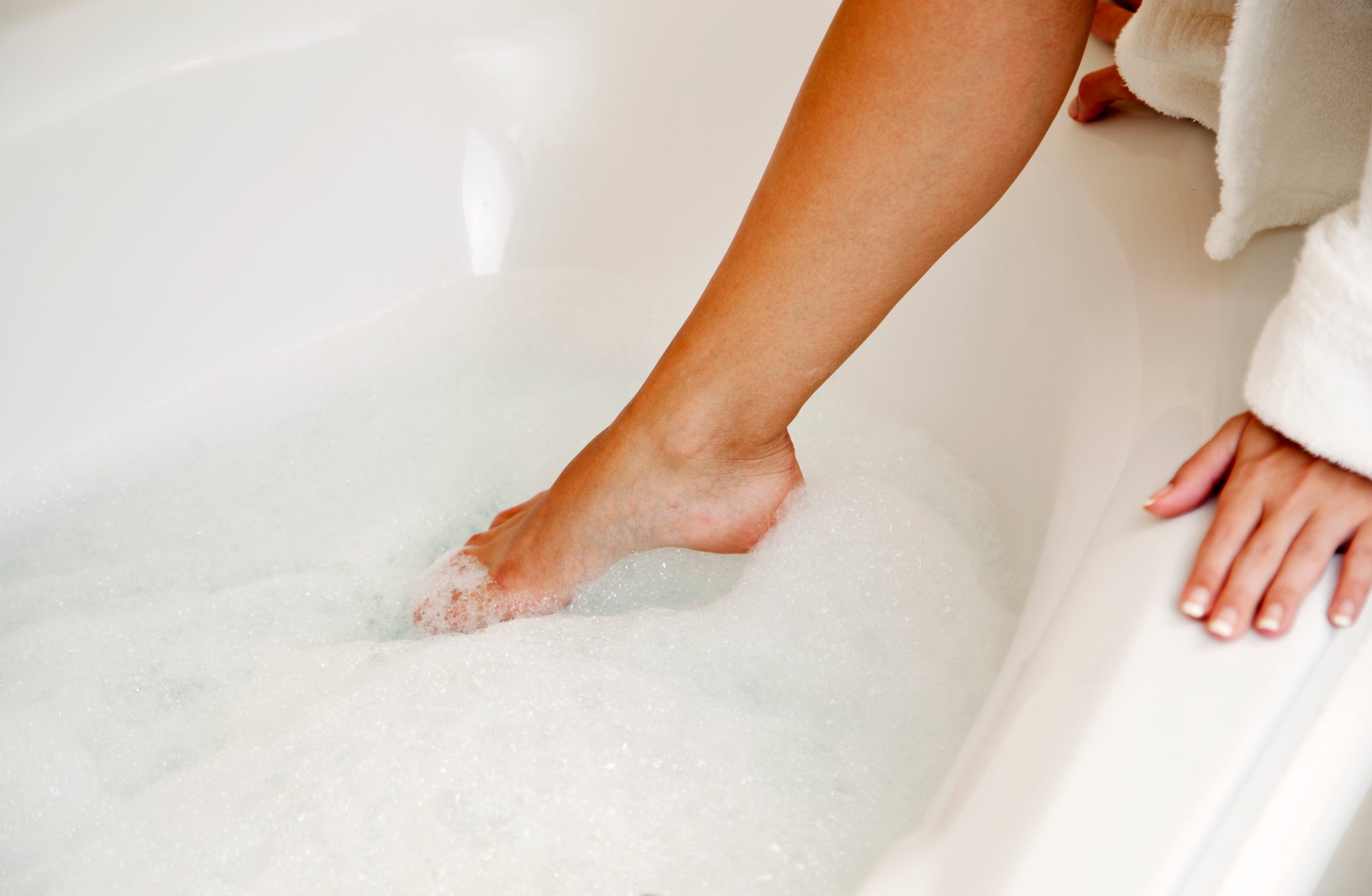 woman stepping into bathtub