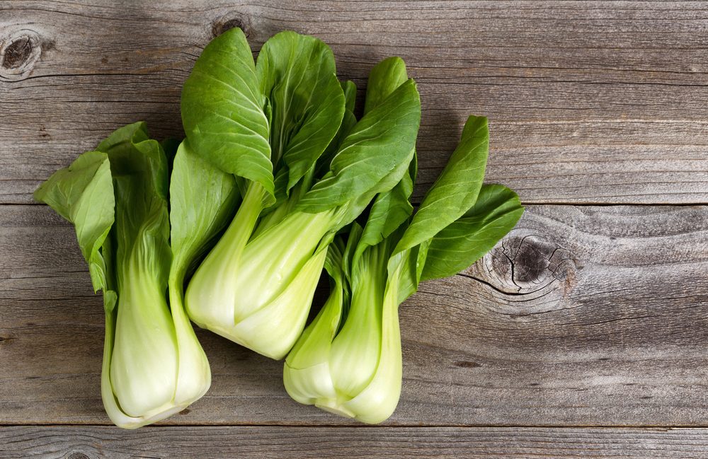 Three bok choy on a wooden background