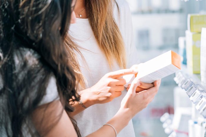 beautiful young couple in beach clothes with volleyball ball in front of cloudy sky