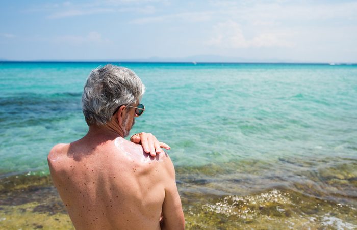 Senior man using sun protection cream on summer vacation