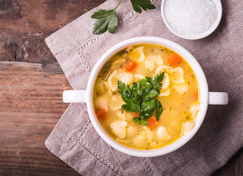 Chicken soup with noodles and parsley.
