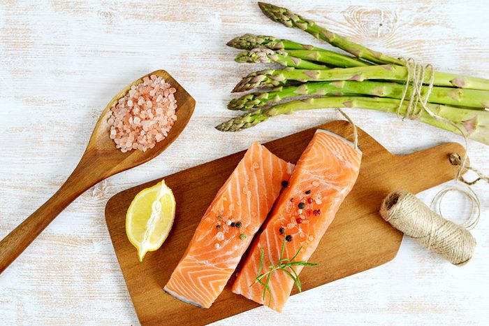 salmon fillets and lemon wedge with asparagus, pink salt, and twine