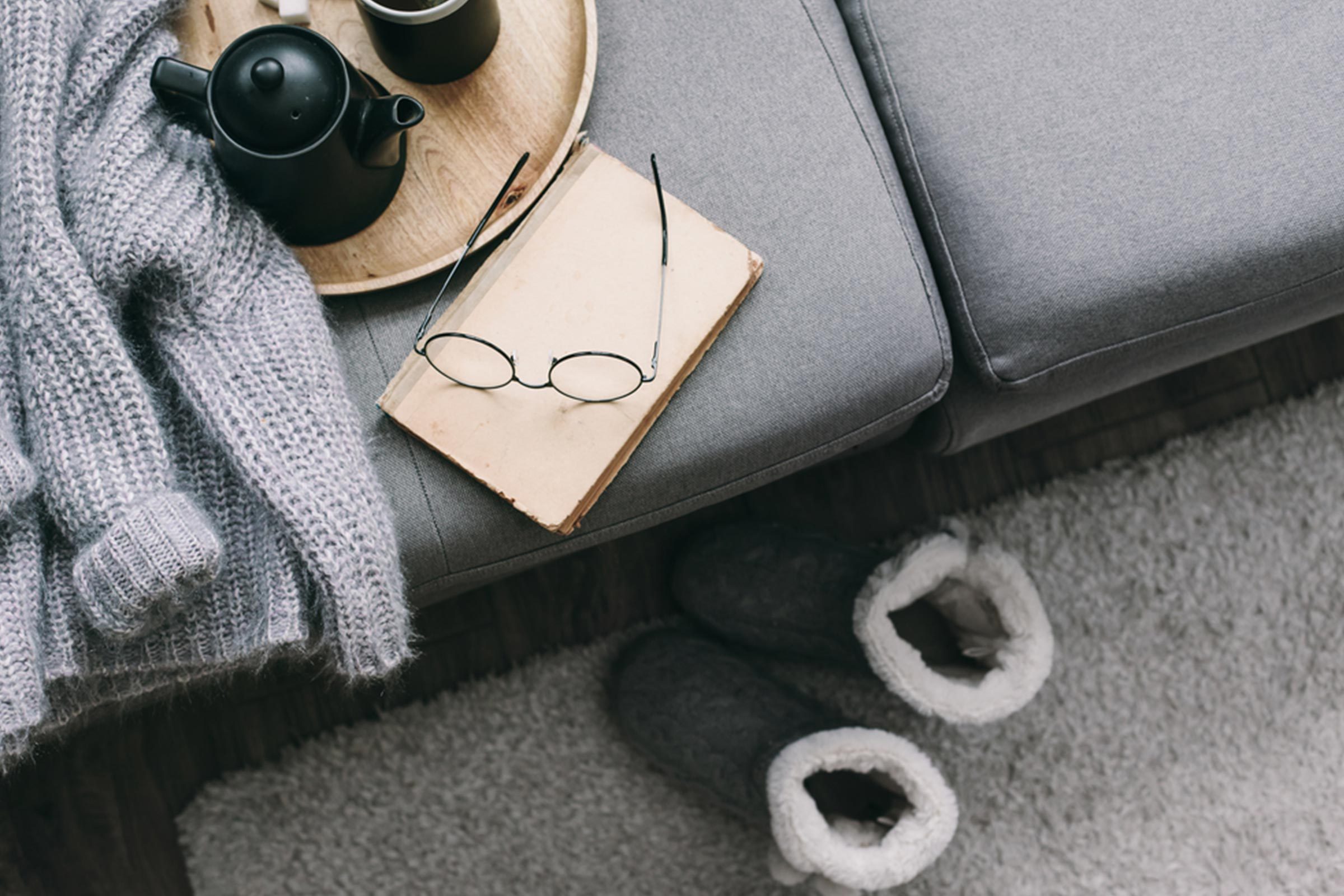 couch with glasses, slippers and journal
