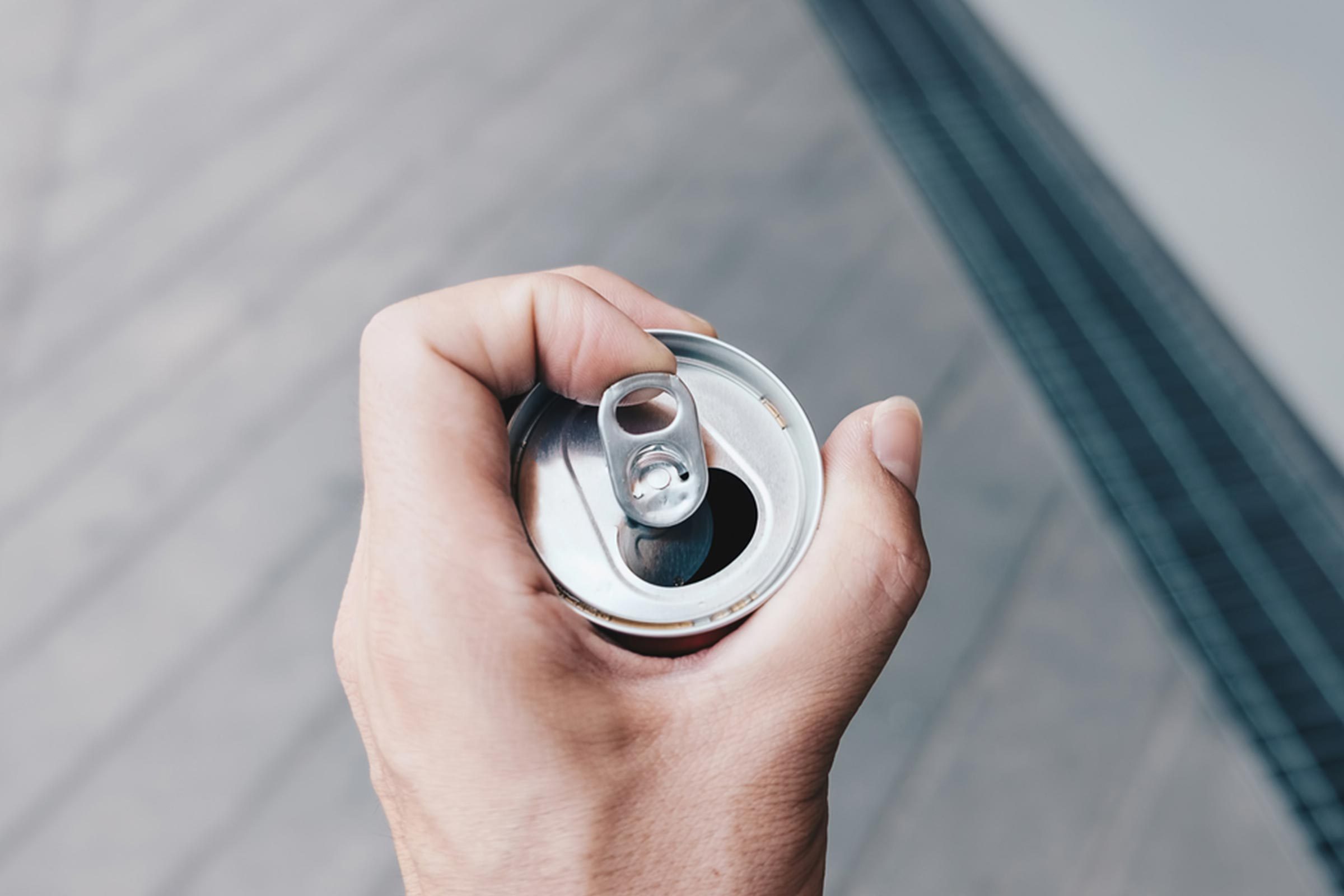 hand holding can of soda