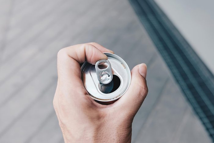 hand holding can of soda