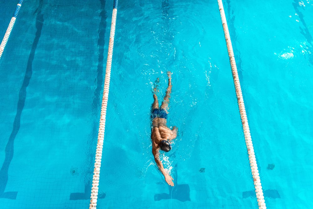 overhead view of swimmer in competition swimming pool with lines