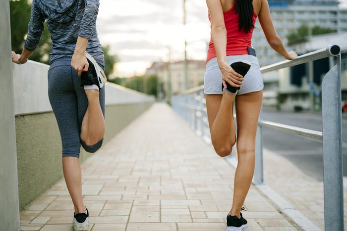 two women stretching before running