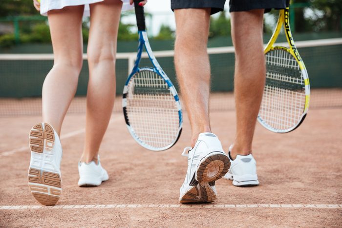 couple carrying tennis rackets