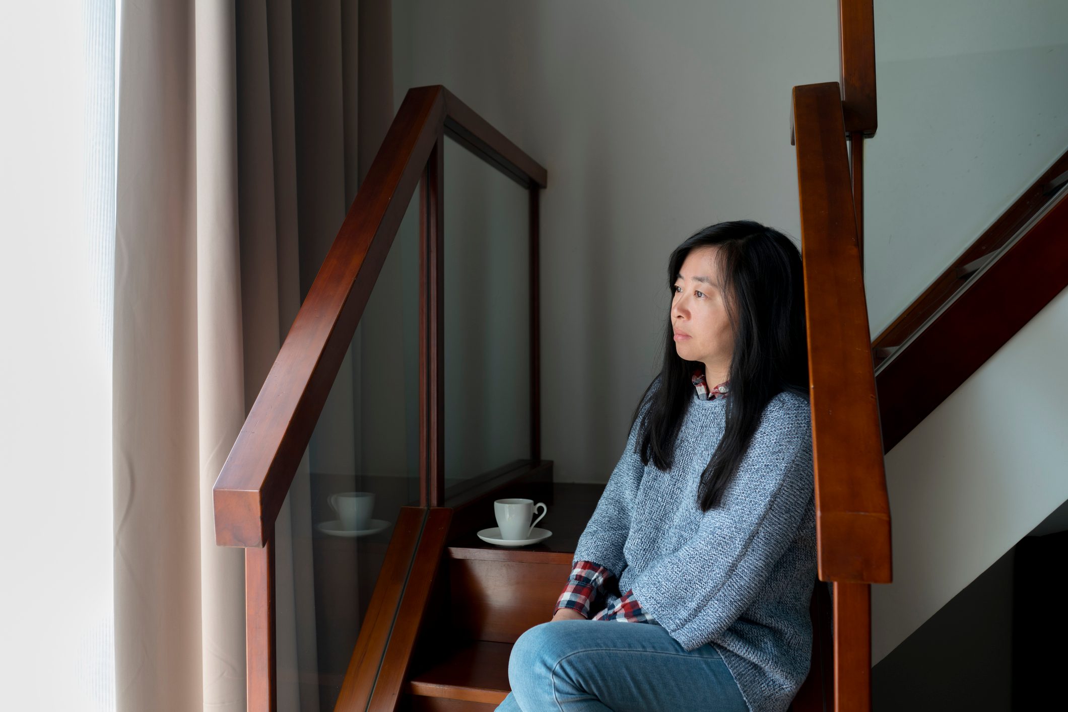 woman sitting at home looking out the window