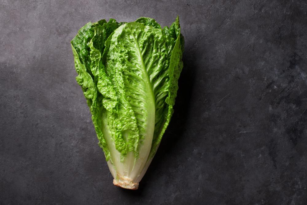 Romaine lettuce salad over stone table. Top view with copy space