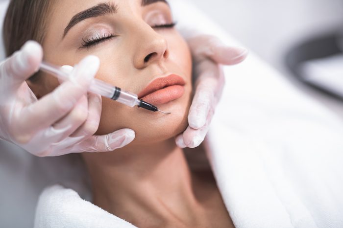 dentist injecting woman's chin with needle