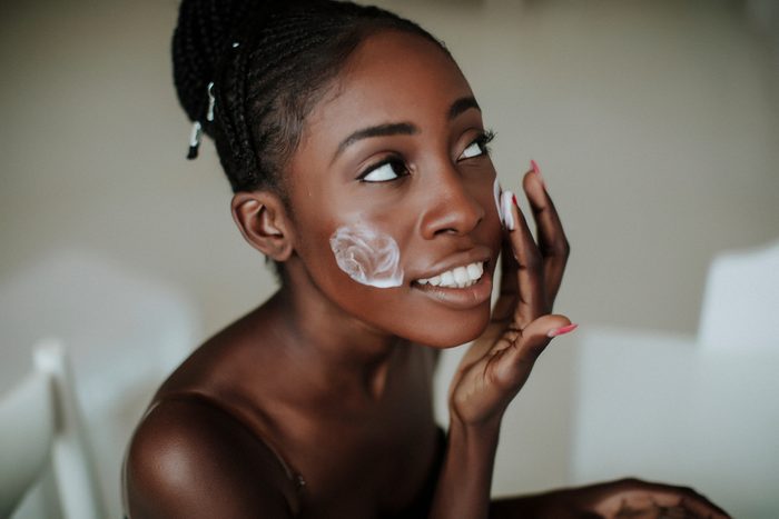 African American girl applying facial skincare product. Sexy woman face. Brutal sexy face girl. Hot babe. Erotic concept. Erotica. Passionate concept. Passion. Adult . Sensual. Sensuality