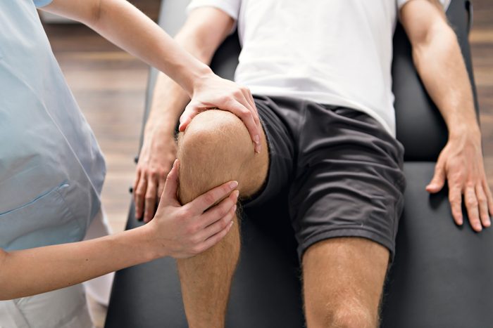 Patient at the physiotherapy doing physical exercises with his therapist