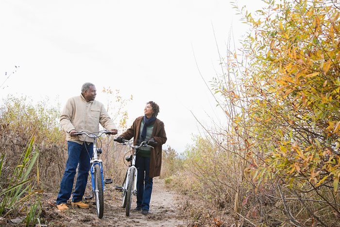 Couple pushing bicycles