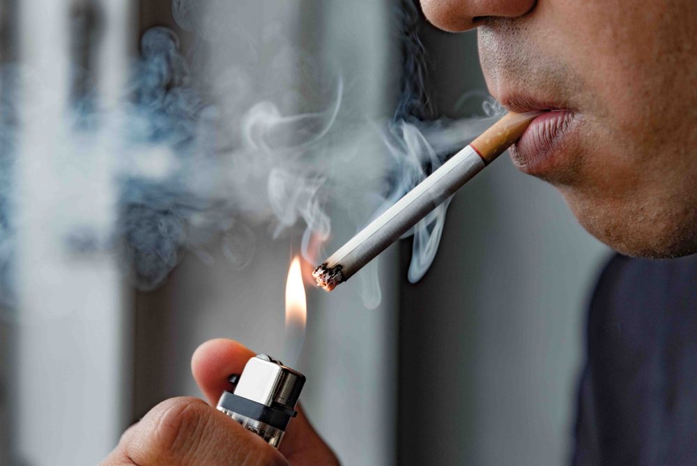 Close up young man smoking a cigarette.