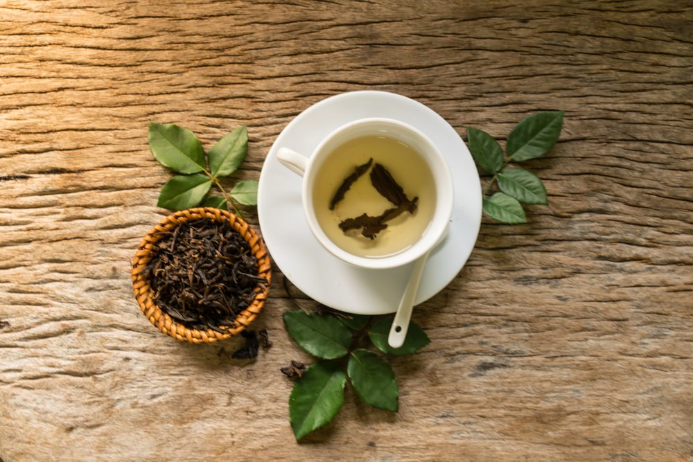 cup and mug of tea with bowl of dried tea and mint leaves