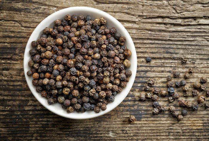 Bowl of whole black peppercorns