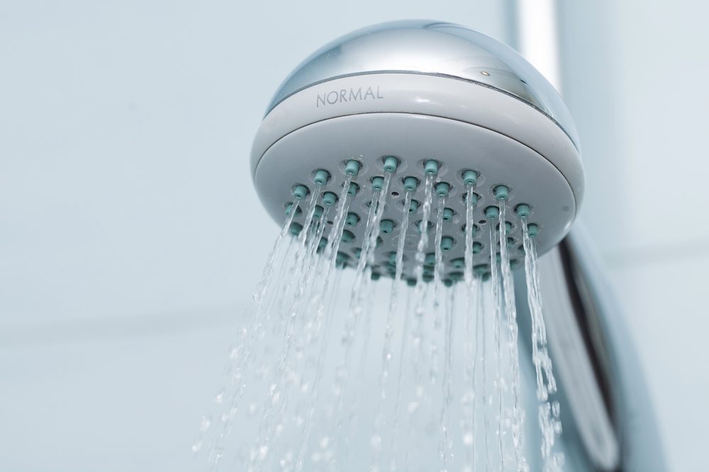 Silver shower with flowing waterin the bathroom