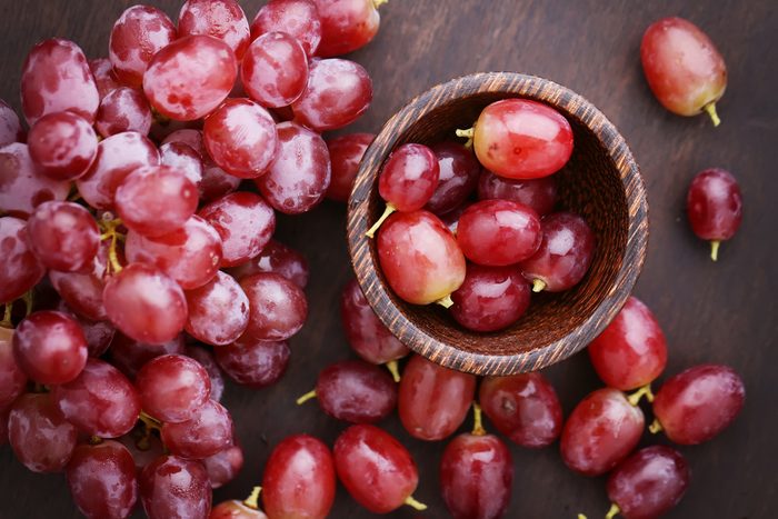 Red grapes on wooden table - vintage filter.
