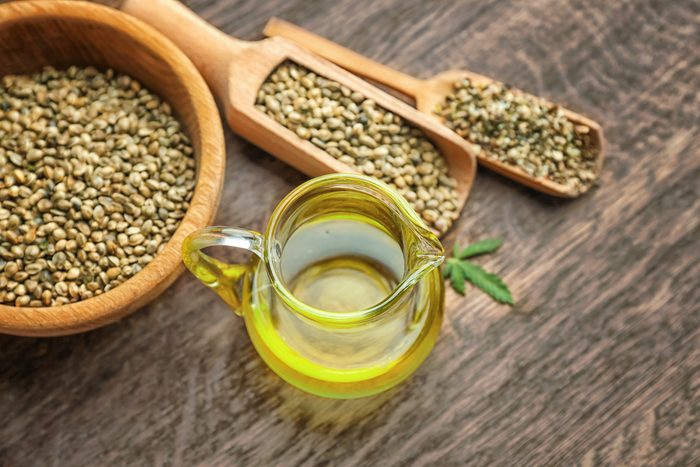 Composition with hemp oil and seeds on wooden background