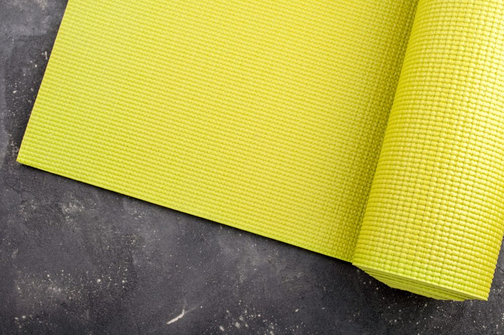 Yoga mat on dark background. Equipment for yoga. Concept healthy lifestyle, sport and diet. Copyspace. Selective focus