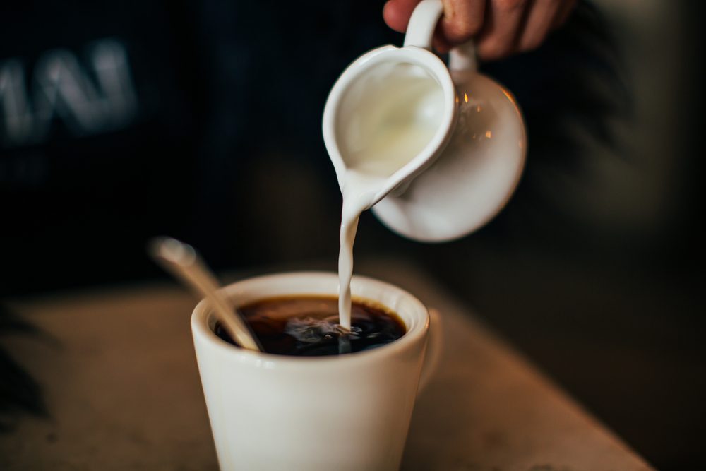 The moment pouring milk into coffee.