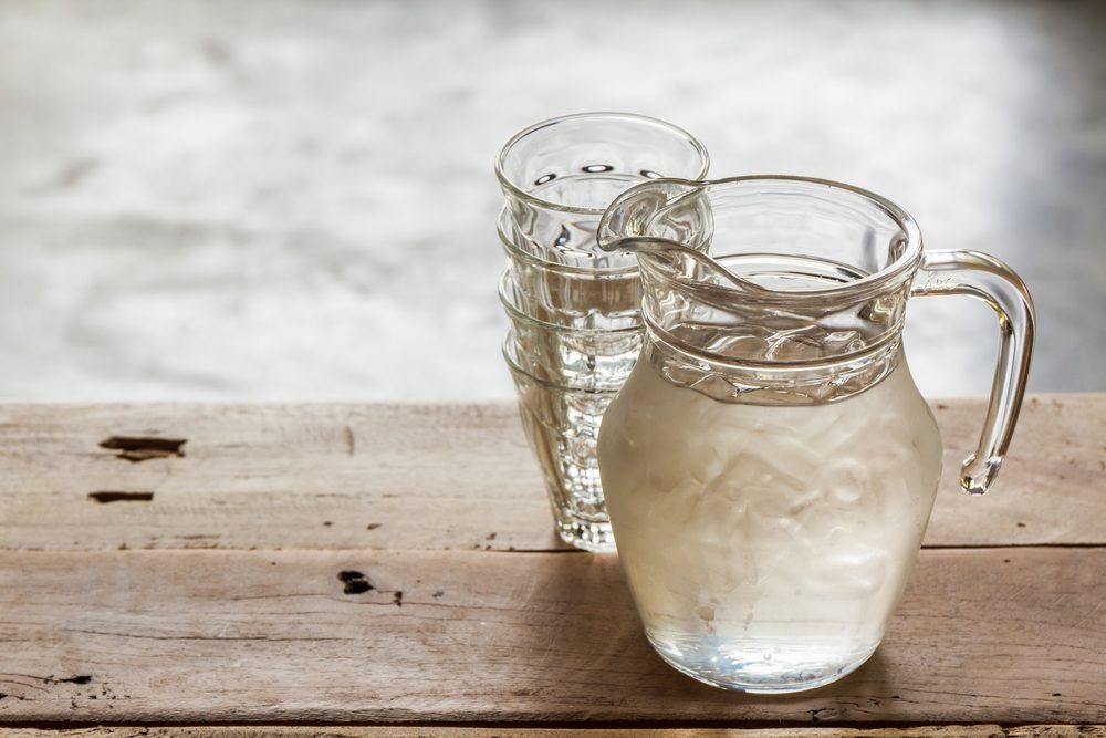 Glass pitcher of water and glasses on table