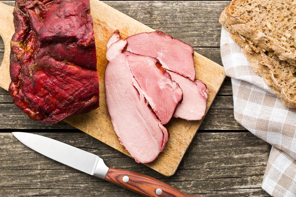 sliced smoked pork meat on cutting board