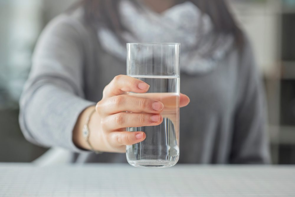 Woman holding glass of water